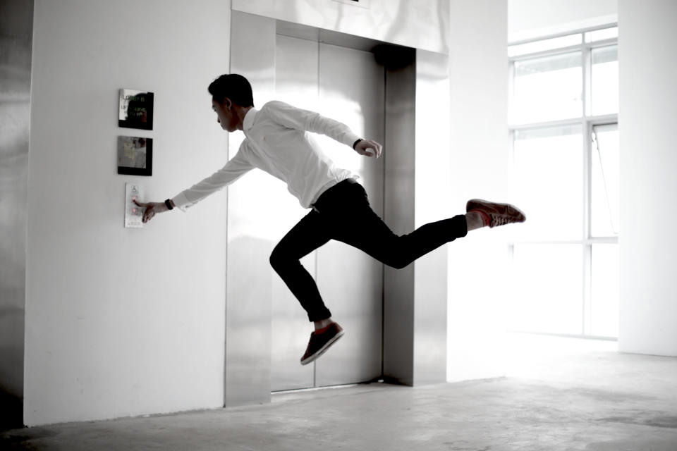 A sharply dressed man presses the button for the lift. Wouldn't it be quicker to fly down? (Levitation SG/ Rex Features)