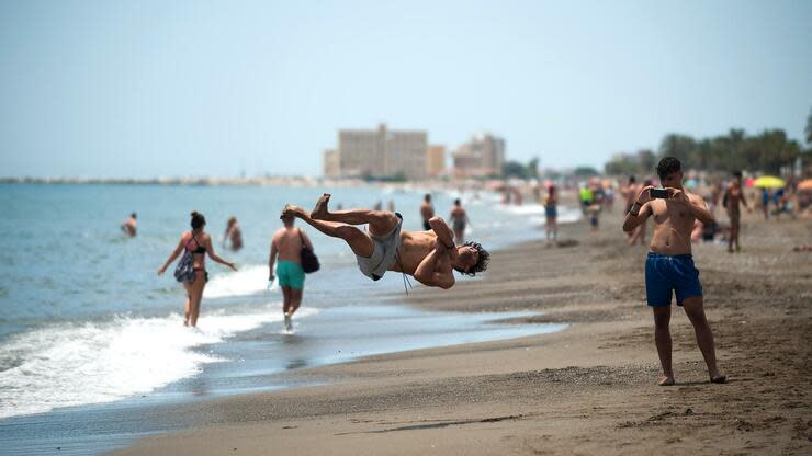 01.06.2020, Spanien, Málaga: Ein junger Mann springt am Misericordia-Strand nach der Lockerung der Anti-Corona-Maßnahmen. In der Phase 2 der Lockerungen dürfen sich Menschen am Strand aufhalten und im Meer baden. Foto: Jesus Merida/SOPA Images via ZUMA Wire/dpa +++ dpa-Bildfunk +++ Foto: dpa