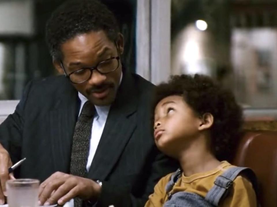 Will Smith and Jaden Smith sitting next to each other at a table in "The Pursuit of Happyness."