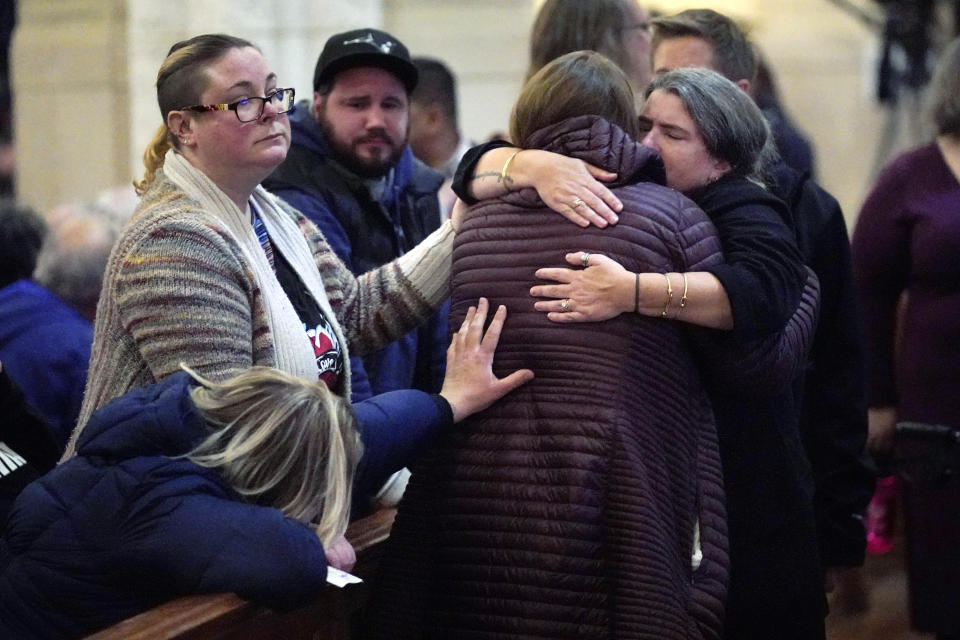 Mourners embrace at a vigil for the victims of mass shootings several days earlier, at the Basilica of Saints Peter and Paul, Sunday, Oct. 29, 2023, in Lewiston, Maine. (AP Photo/Robert F. Bukaty)
