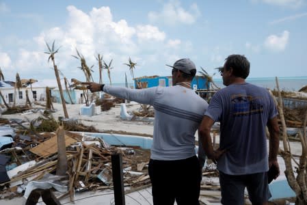 Men look at devastated houses after Hurricane Dorian hit the Abaco Islands in Treasure Cay