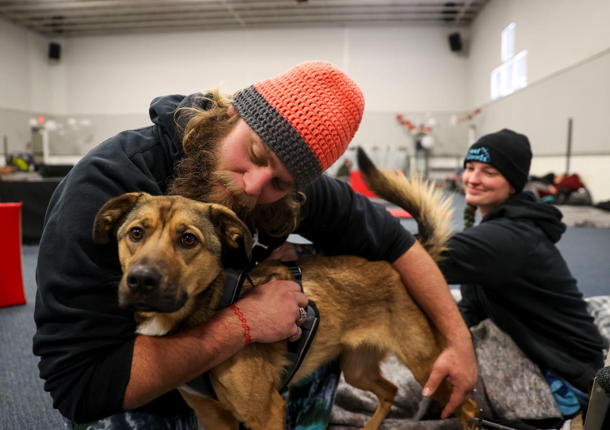 TJ and Savahna Osborne shelter from the cold temperatures with their dog, Spaz, at Seed of Faith Ministries in Salem on Sunday. The warming shelter has been open 24 hours a day since Friday night.