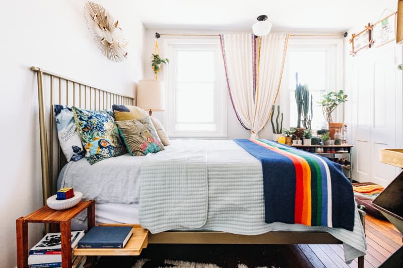 Bed with decorative throw pillows and colorful blanket featuring blankets.