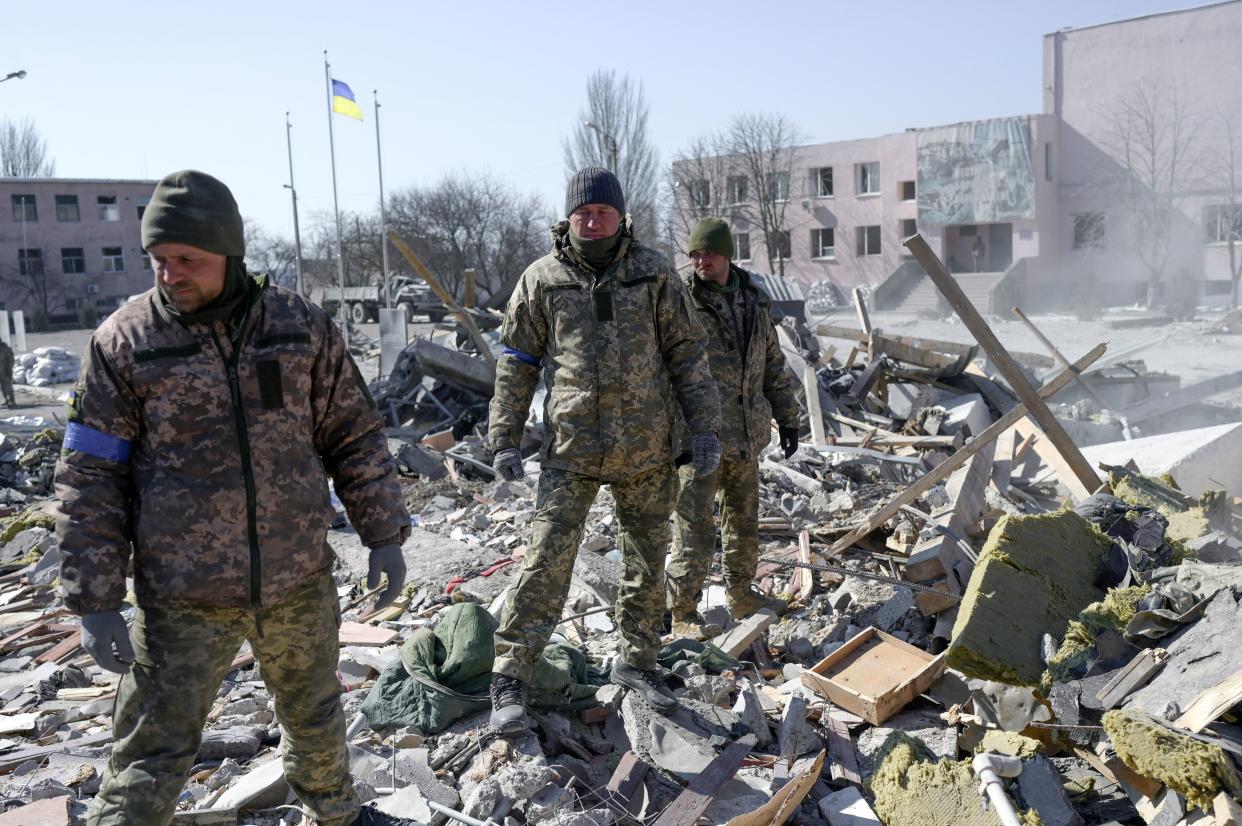 Ukrainian soldiers search for bodies in the debris at the military school hit by Russian rockets the day before, in Mykolaiv, southern Ukraine, on March 19, 2022. - Ukrainian media reported that Russian forces had carried out a large-scale air strike on Mykolaiv, killing at least 40 Ukrainian soldiers at their brigade headquarters. (Photo by BULENT KILIC / AFP) (Photo by BULENT KILIC/AFP via Getty Images)