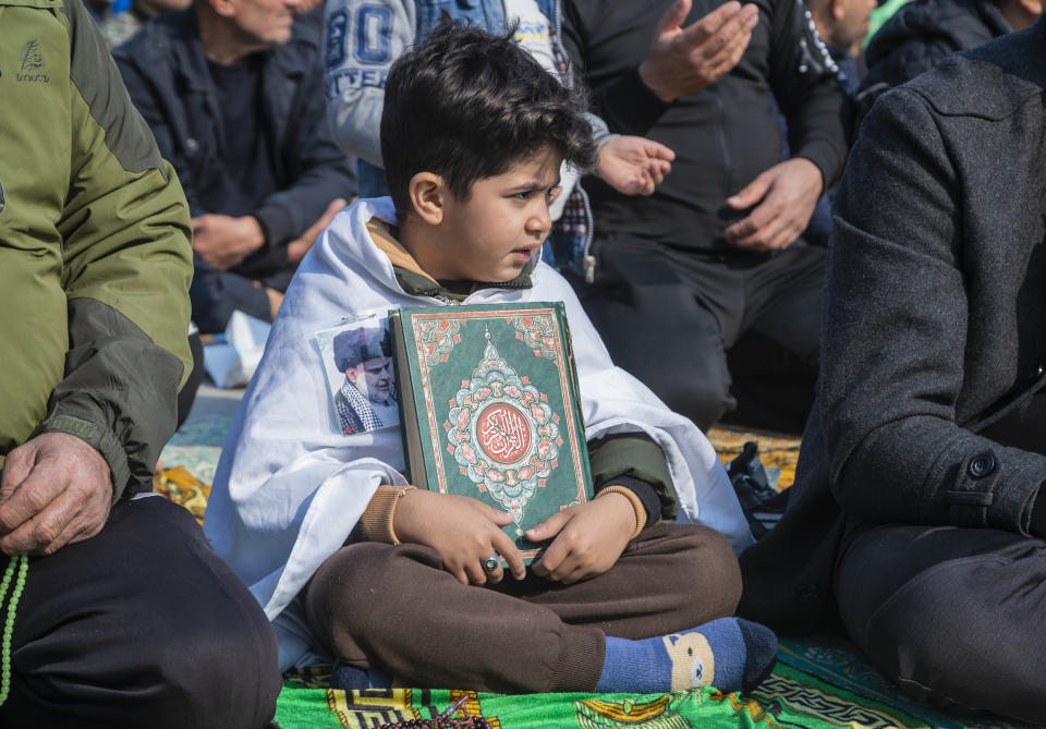 A child holds the Quran, the Muslim holy book, in response to the burning of a copy of the Quran in Sweden, during open-air Friday prayers in Baghdad, Iraq, Friday, Jan. 27, 2023. (AP Photo/Hadi Mizban)