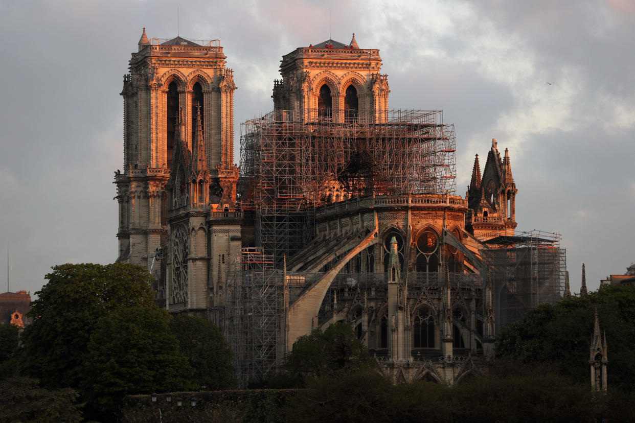 PARIS, FRANCE - APRIL 17: Notre-Dame Cathedral is seen at sunrise following a major fire on Monday on April 17, 2019 in Paris, France. A fire broke out on Monday afternoon and quickly spread across the building, causing the famous spire to collapse. The cause is unknown but officials have said it was possibly linked to ongoing renovation work. (Photo by Dan Kitwood/Getty Images)