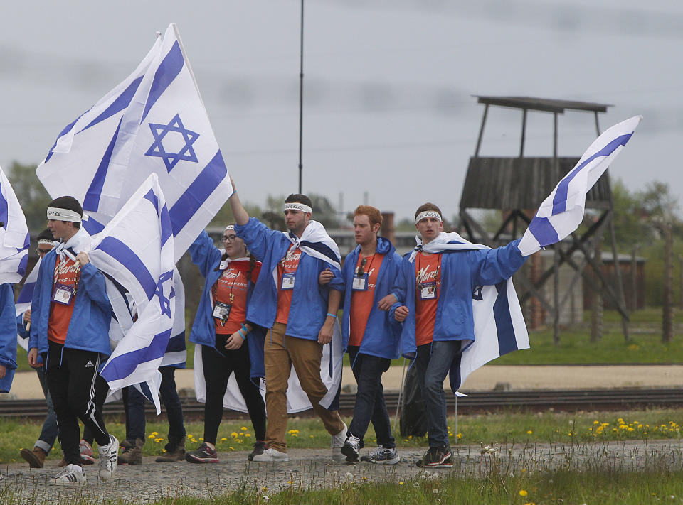 Young jewish people from Israel and other countries march in silence between the two parts of Auschwitz-Birkenau, the Nazi German death camp, in an annual march of the living in Oswiecim, Poland, on Monday, April 28, 2014, which is held in memory of some 6 million Jews killed during the Holocaust. This year, the march honors some 430,000 Hungarian Jews killed in Birkenau gas chambers in 1944. (AP Photo/Czarek Sokolowski)