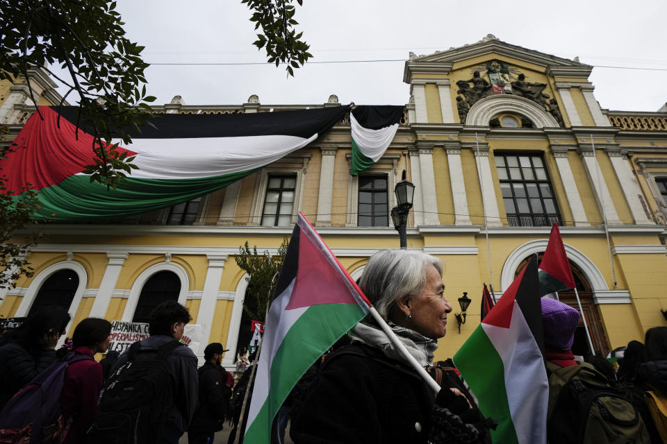 Una mujer camina con una bandera palestina mientras estudiantes universitarios se reúnen en Santiago, Chile, para un acto conmemorativo de la Nakba, la palabra árabe para catástrofe, el 15 de mayo de 2024. (AP Foto/Esteban Felix)