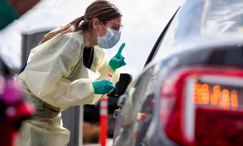 Ashley Layton at St. Luke's Meridian Medical Center takes a swab sample at an outdoor drive-thru screening station for COVID-19 in Meridian, Idaho, on March 17.