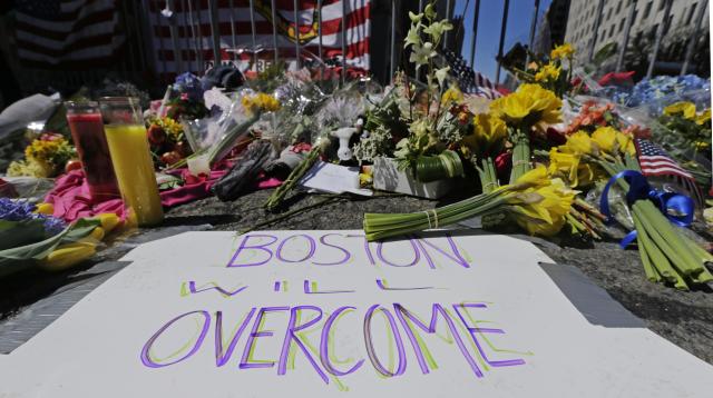 Boston Red Sox's Jonny Gomes places the championship trophy and a Red Sox  baseball jersey at the Boston Marathon Finish Line during a pause in their  World Series victory rolling rally in