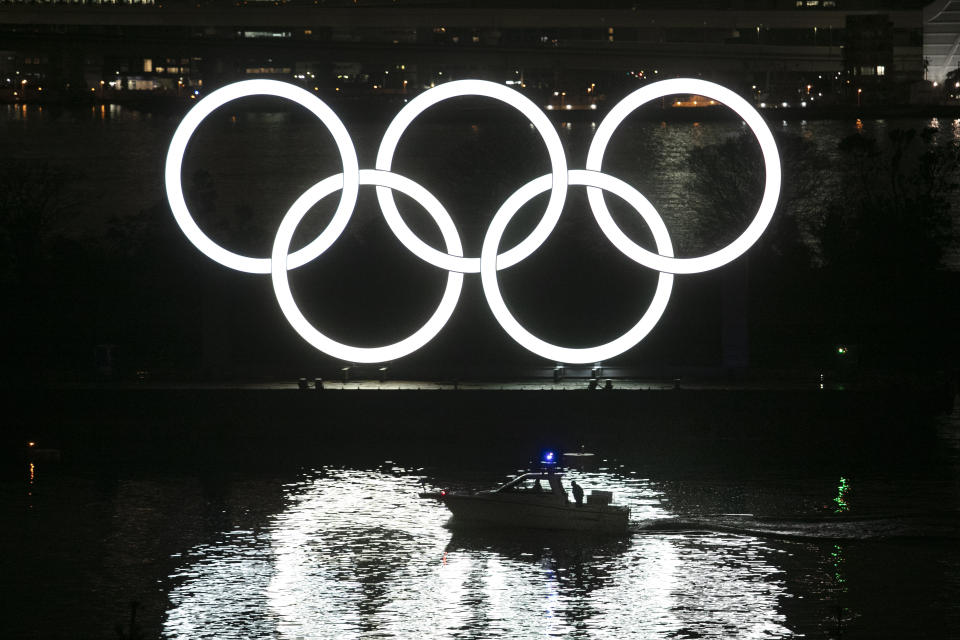 A small boat passes by the illuminated Olympic rings during a ceremony held to celebrate the 6-months-to-go milestone for the Tokyo 2020 Olympics Friday, Jan. 24, 2020, in the Odaiba district of Tokyo. (AP Photo/Jae C. Hong)