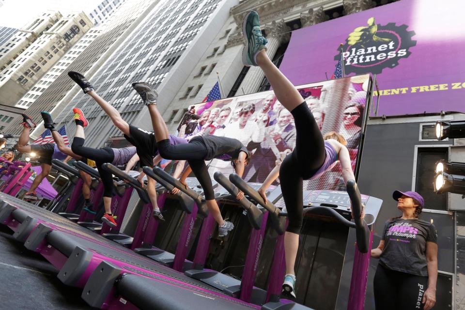 Planet Fitness dancers perform on treadmills outside the New York Stock Exchange after the company's IPO