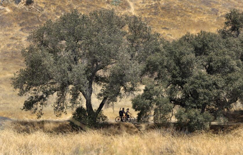 CALABASAS, CA-AUGUST 20, 2018: People ride their bikes during a visit tol Malibu Creek State Park in Calabasas on August 20, 2018. A series of shootings in and around the park have proven difficult for detectives to solve, or even piece together. A month after a young father was killed, residents are demanding answers. (Mel Melcon/Los Angeles Times)