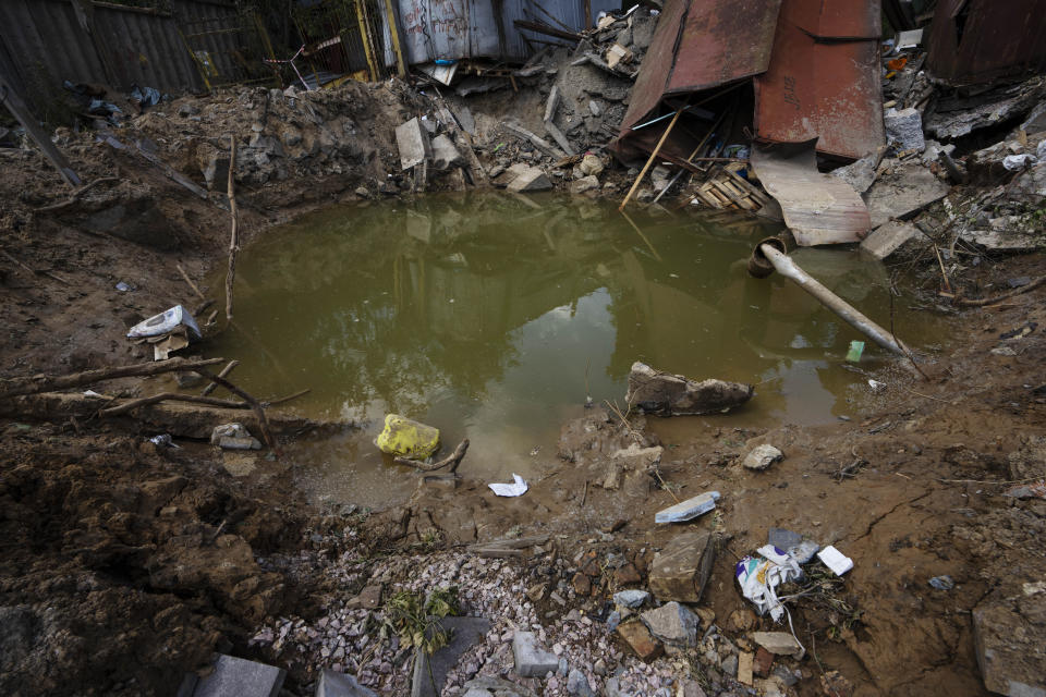 A crater in the courtyard of kindergarten in the aftermath of Russian missile strikes fired toward Kyiv early Sunday, Ukraine, Monday, June 27, 2022. (AP Photo/Nariman El-Mofty)