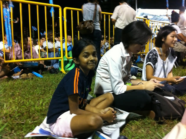 The young daughter of WP member L Sundaram supports her father from the field, sitting on newspapers provided by this reporter when ants started to bite at her feet. (Yahoo! photo)