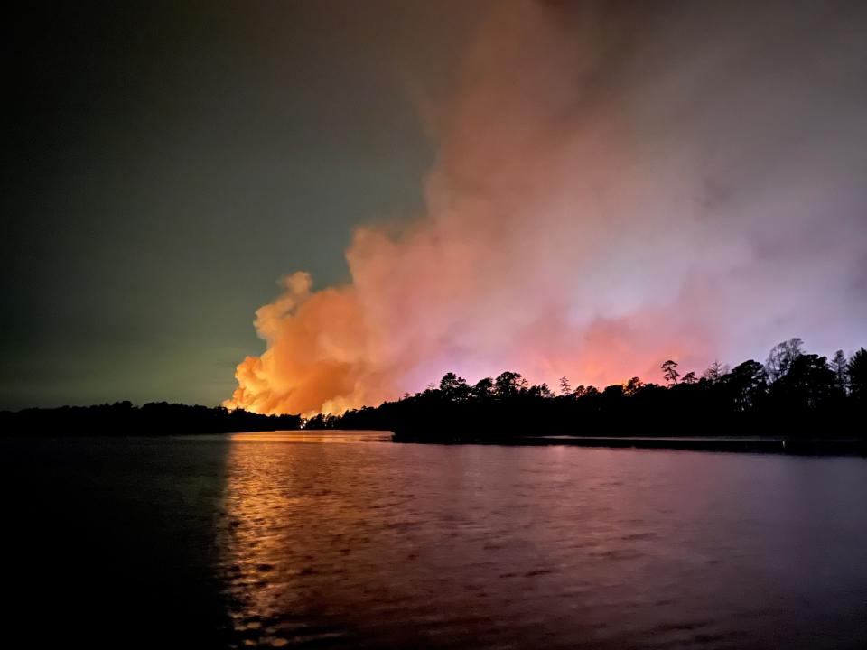 Smoke billows from across Lake Horicon in Lakehurst where a major wildfire threatened the town early Wednesday, April 12, 2023.