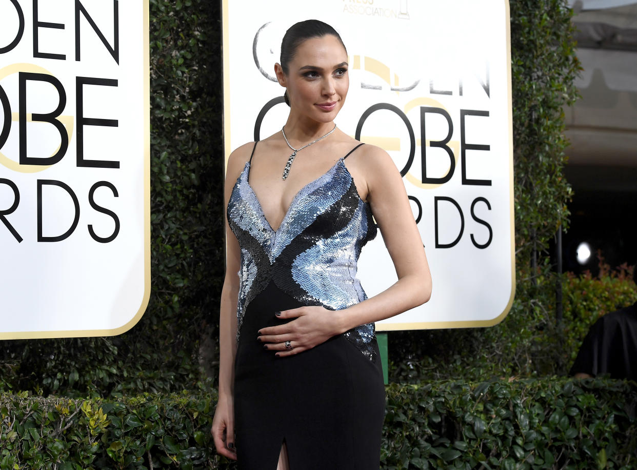 Gal Gadot looks absolutely radiant hugging her baby bump on the Golden Globes red carpet