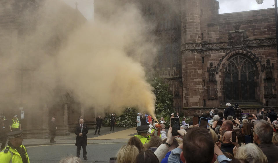 En esta fotografía proporcionada por Just Stop Oil, una manifestante usa un extintor para diseminar pintura polvo afuera de la Catedral de Chester durante la boda de Hugh Grosvenor, el duque de Westminster, y Olivia Henson, en Chester, Inglaterra, el viernes 7 de junio de 2024. La policía dijo que una mujer de 69 años y una mujer de 73 fueron arrestadas bajo sospecha de delitos contra el orden público. El grupo Just Stop Oil dijo que las dos eran integrantes de la organización y exigían el fin de la extracción de combustibles fósiles. (Just Stop Oil vía AP)