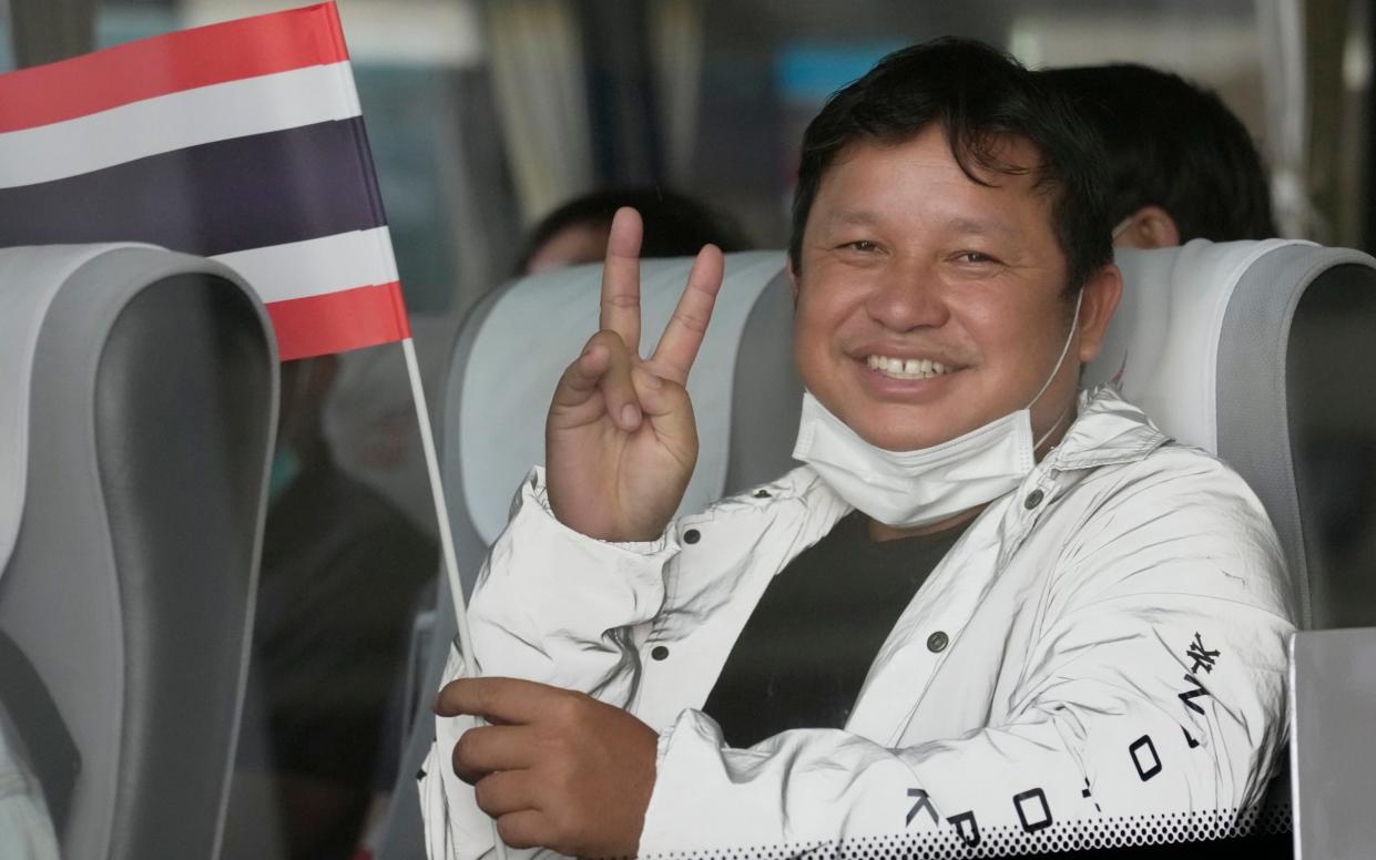 A Thai worker who was evacuated from Israel, reacts in a bus on the arrival at military airport, before going back to his home town in Bangkok, Thailand, Monday, Oct. 16, 2023.