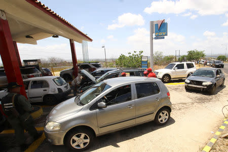 People with vehicles wait in line to refuel at a gas station of the state oil company PDVSA in Ciudad Guayana, Venezuela, May 17, 2019. REUTERS/William Urdaneta