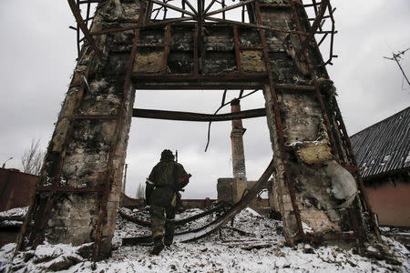 A member of the armed forces of the separatist self-proclaimed Donetsk People's Republic walks near a building destroyed during battles with the Ukrainian armed forces in Vuhlehirsk, Donetsk region, Ukraine, in this February 4, 2015 file photo. REUTERS/Maxim Shemetov/Files