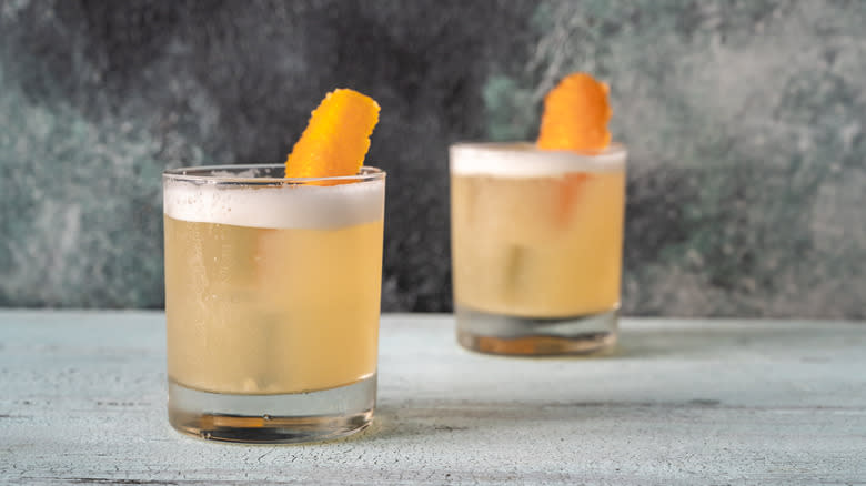two garnished whiskey sour cocktails