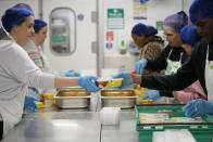 Volunteers from the charity 'The Felix Project' prepare meals in the kitchen of their hub in London, Wednesday, May 4, 2022. Across Britain, food banks and community food hubs that helped struggling families, older people and the homeless during the pandemic are now seeing soaring demand. The cost of food and fuel in the U.K. has risen sharply since late last year, with inflation reaching the highest level in 40 years. (AP Photo/Frank Augstein)