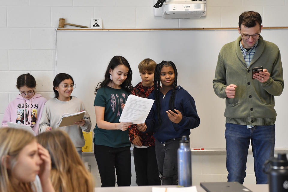 Teacher Donnie Piercey, right, works with students as they perform a three-scene play written by ChatGPT during his class at Stonewall Elementary in Lexington, Ky., Monday, Feb. 6, 2023. Parameters of the play were entered into the ChatGPT site, along with instructions to set the scenes inside of a fifth-grade classroom. Line-by-line, it generated fully-formed scripts, which the students edited, briefly rehearsed and then performed. (AP Photo/Timothy D. Easley)