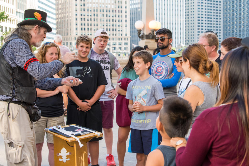 Magician performing on the street for young kids and adults