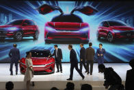 In this April 16, 2019, photo, attendees take a close look at cars from BYD at the Auto Shanghai 2019 show in Shanghai. China's electric car sales are stalling following the end of multibillion-dollar subsidies that made it the biggest market for the technology. Communist leaders want to make China a leader in electric cars but are shifting the burden to the industry by imposing mandatory sales quotas (AP Photo/Ng Han Guan)