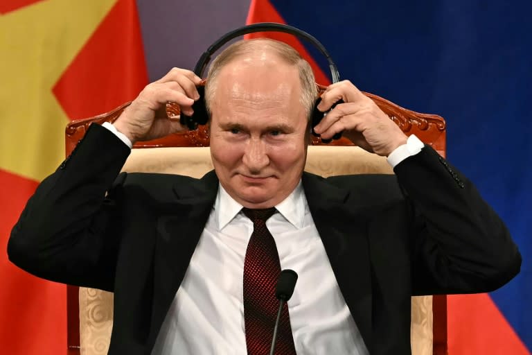 El presidente ruso, Vladimir Putin, se ajusta los auriculares durante un acto de su visita oficial a Vietnam, el 20 de junio de 2024 en Hanói (Manan Vatsyayana)