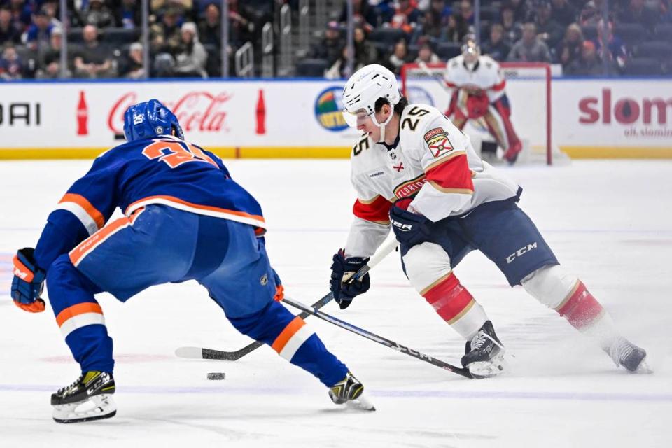 Jan 27, 2024; Elmont, New York, USA; Florida Panthers right wing Mackie Samoskevich (25) skates the puck across the blue line defended by New York Islanders defenseman Sebastian Aho (25) during the first period at UBS Arena.