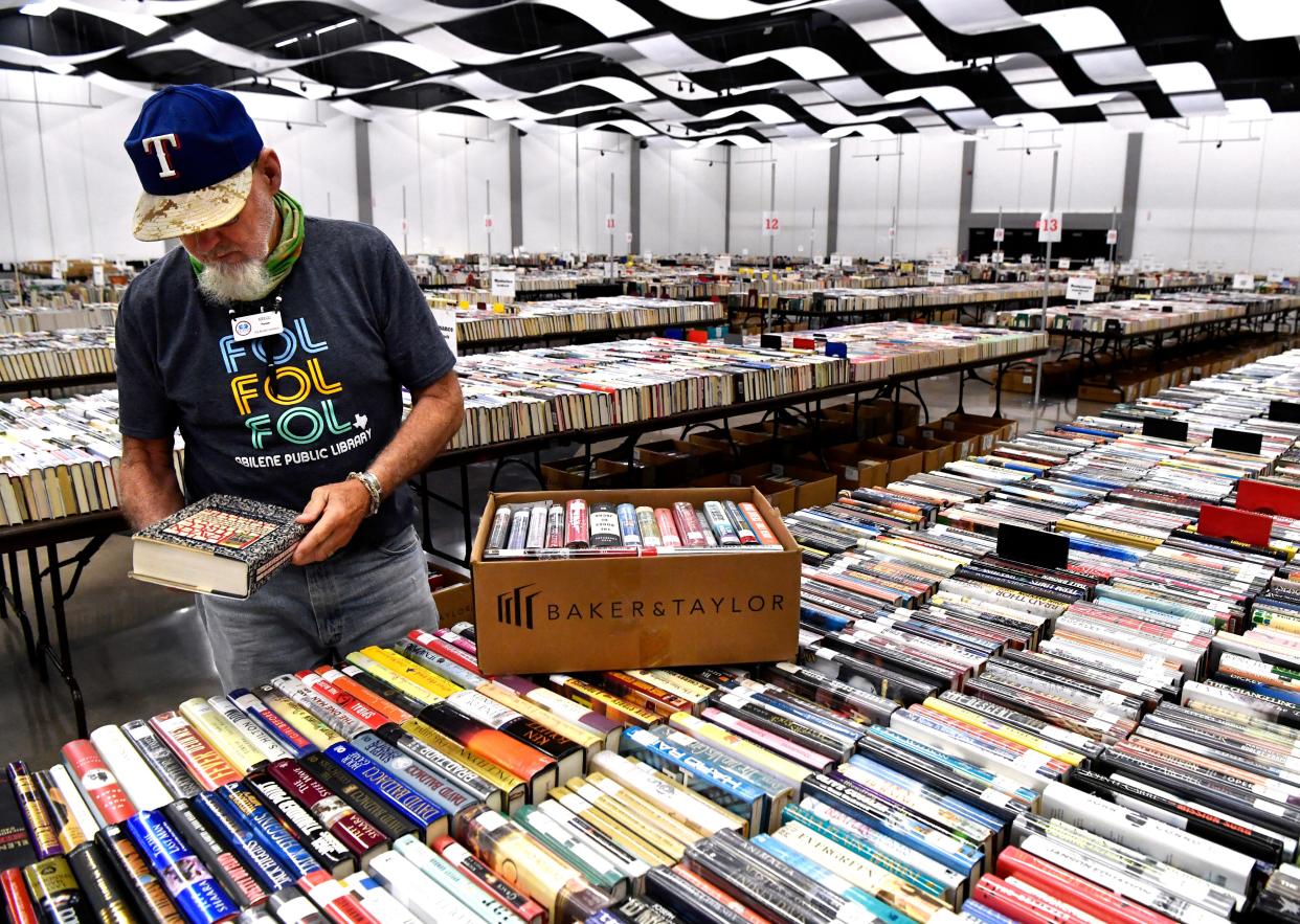 Kregg Pierson sorts books Thursday before the annual Friends of the Abilene Public Library book sale in the Abilene Convention Center.