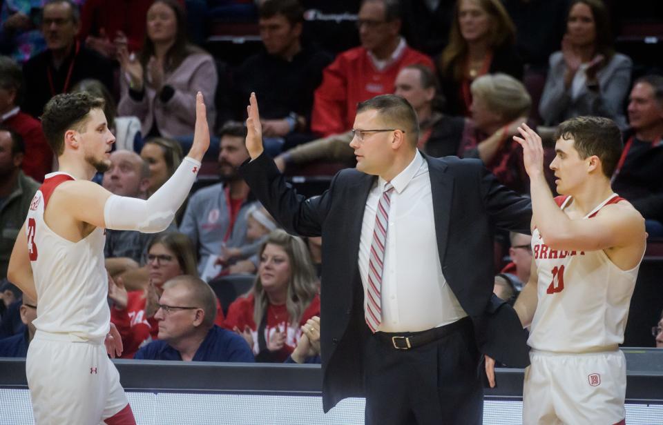 Bradley head coach Brian Wardle, middle, greets Connor Hickman, right, and Ville Tahvanainen as they come off the court late in the second half against Evansville on Wednesday, Jan. 11, 2023 at Carver Arena in Peoria. The Braves defeated the Aces 91-46.