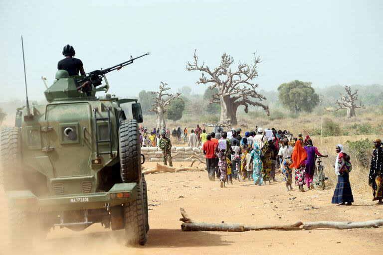 Un vehículo blindado del ejército nigeriano protege a las mujeres de Chibok mientras caminan por una carretera en Chibok, noreste de Nigeria, el 5 de marzo de 2015