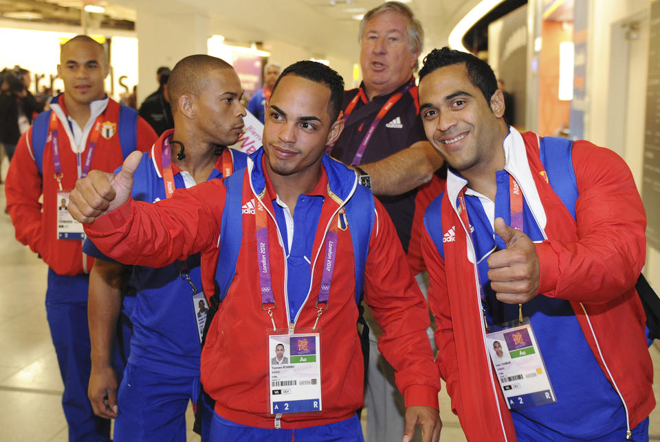 Members of the Cuban weightlifting squad arrive at Heathrow airport, London, July 16, 2012. The London 2012 Olympic Games start in 11 days time. REUTERS/Paul Hackett (BRITAIN - Tags: SPORT OLYMPICS)