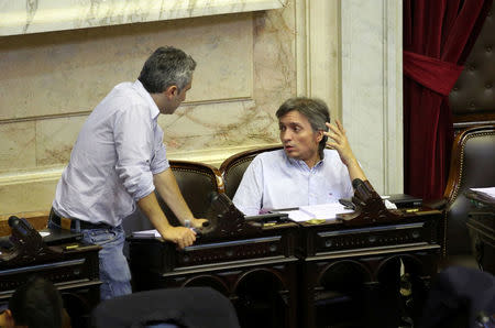 Lawmaker and son of former Argentine President Cristina Fernandez de Kirchner, Maximo Kirchner (R), talks to his colleague Andres Larroque during a debate at the Argentine Congress in Buenos Aires, Argentina December 18, 2017. REUTERS/Agustin Marcarian