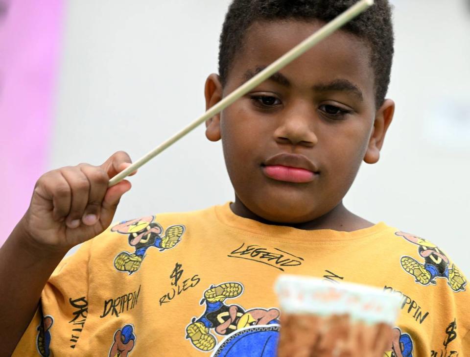 Josiah Mooney, 7, plays a drum he crafted during the 7th annual Juneteenth Reading Conference.