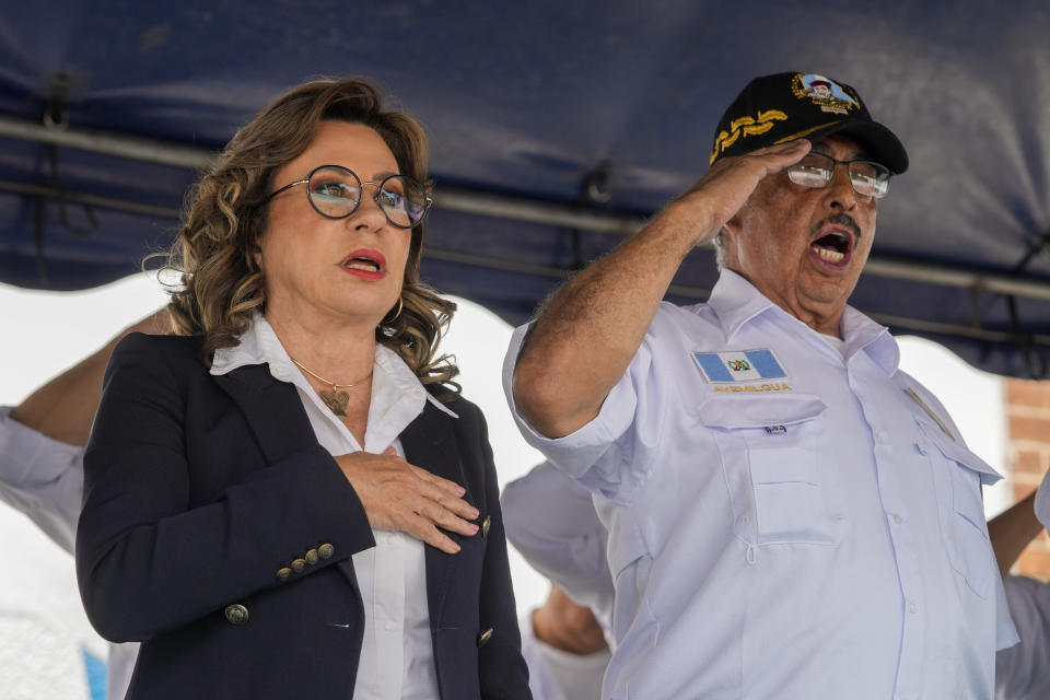 Sandra Torres, presidential candidate of UNE party, left, and retired general Horacio Soto Salan sing the national anthem, during a meeting with Guatemalan Army veterans in Guatemala City, Tuesday, Aug. 15, 2023. Torres will face Bernardo Arévalo of the Seed Movement party in an Aug. 20 runoff election. (AP Photo/Moises Castillo)