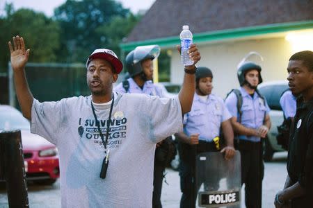 Protesters gesture and chant as they stand near Missouri Highway Patrol officers during ongoing demonstrations in reaction to the shooting of Michael Brown in Ferguson, Missouri August 16, 2014. REUTERS/Lucas Jackson