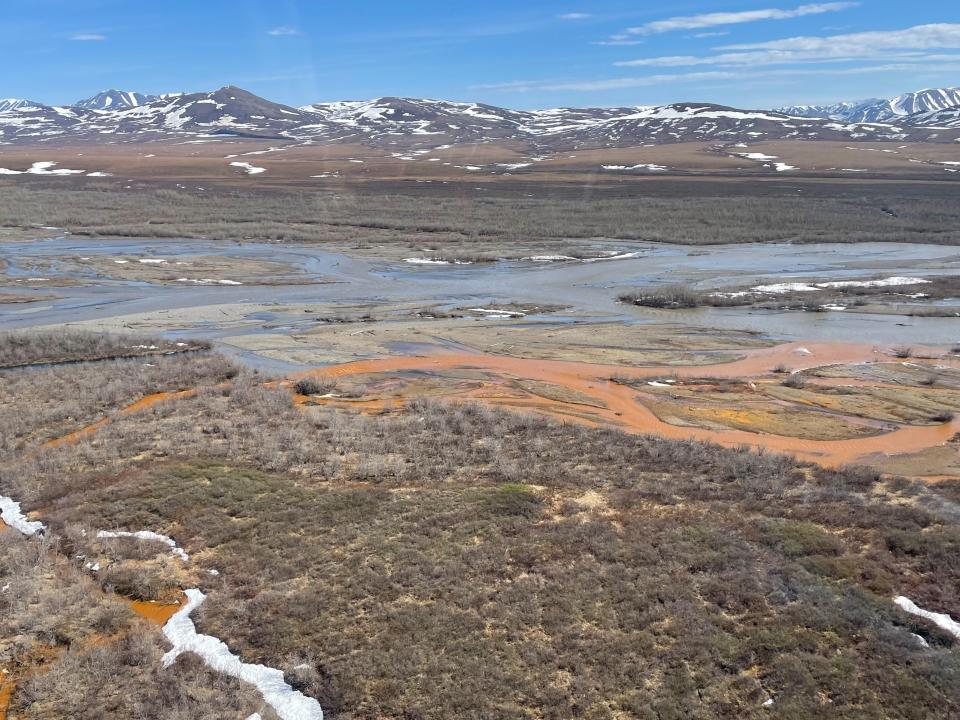 An orange tributary joins the Kugaroruk River in Alaska.