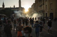 Demonstrators run from tear gas fired by police near the parliament building during a protest against the political elite and the government after a deadly explosion at the seaport last week which devastated large parts of the capital, in Beirut, Lebanon, Sunday, Aug. 9, 2020. The massive explosion is just the latest in multiple crises that have hit Lebanon the past year, including massive protests, economic collapse and the coronavirus pandemic. Some Lebanese, whether poor or middle class, now feel their resolve is simply broken. (AP Photo/Felipe Dana)