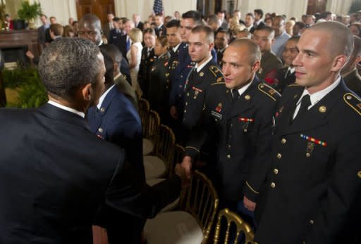 US President Barack Obama shakes hands with active duty US service members, after they became US citizens during a naturalization ceremony in the East Room of the White House in Washington, DC, July 4, 2012