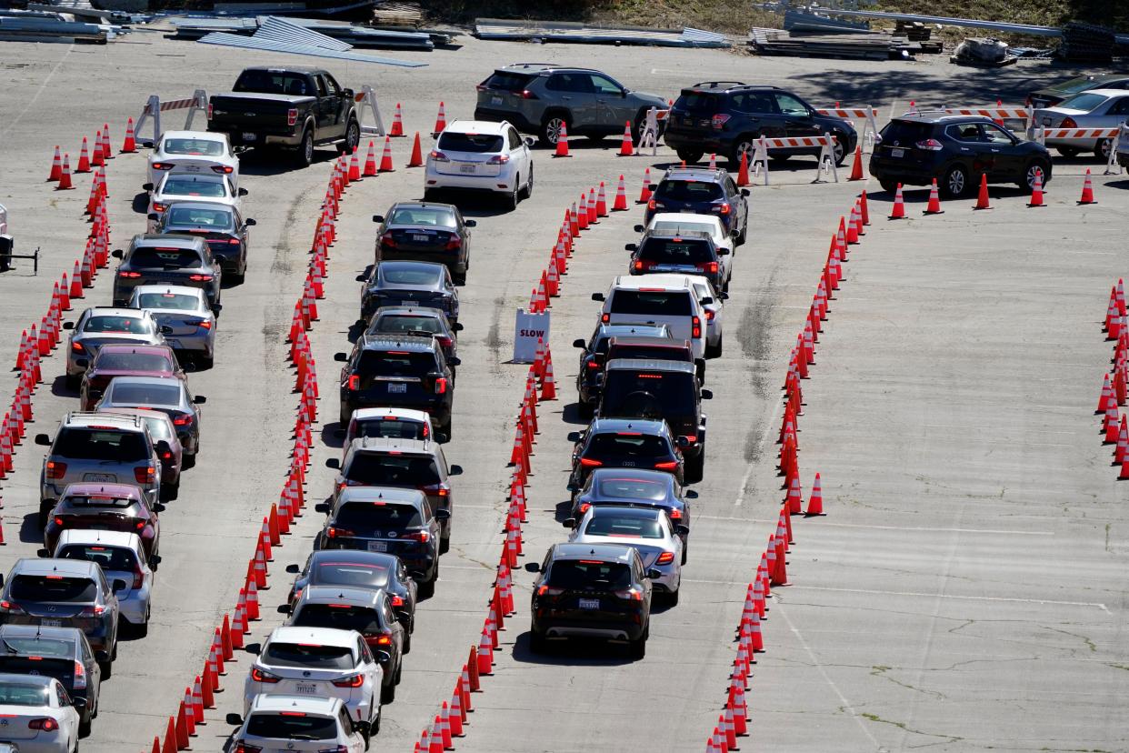 Motorists line up at a COVID-19 vaccination site at Dodger Stadium on Tuesday, Feb. 23, 2021, in Los Angeles, Calif.