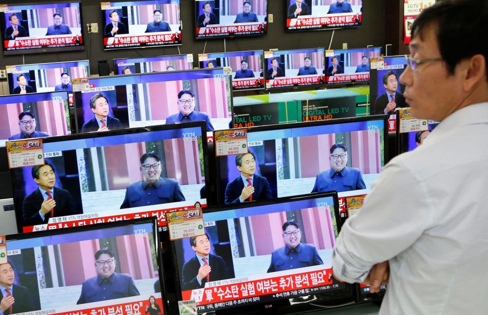 A sales assistant watches TV sets broadcasting a news report on North Korea's fifth nuclear test