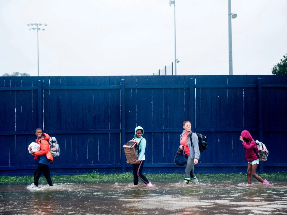 People escape a flooded neighborhood on August 29, 2017 in Houston, TX.