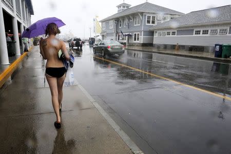 Topless activist Kaila J. walks through the rain following a "Free the Nipple" demonstration in Hampton Beach, New Hampshire August 23, 2015. REUTERS/Brian Snyder