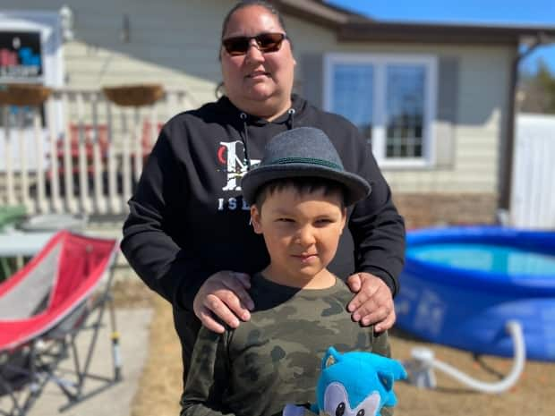 Renee Sanderson stands with her nine-year-old son, Kane, outside their Yellowknife home in spring of 2021. Sanderson was one of many parents who had just over 12 hours to figure out how to go back to remote learning as of Thursday. (John Van Dusen/CBC - image credit)