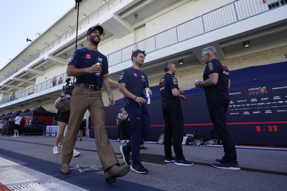 AlphaTauri driver Daniel Ricciardo, left, of Australia, walks in the paddock before the Formula One U.S. Grand Prix auto race at Circuit of the Americas, Thursday, Oct. 19, 2023, in Austin, Texas. (AP Photo/Darron Cummings)