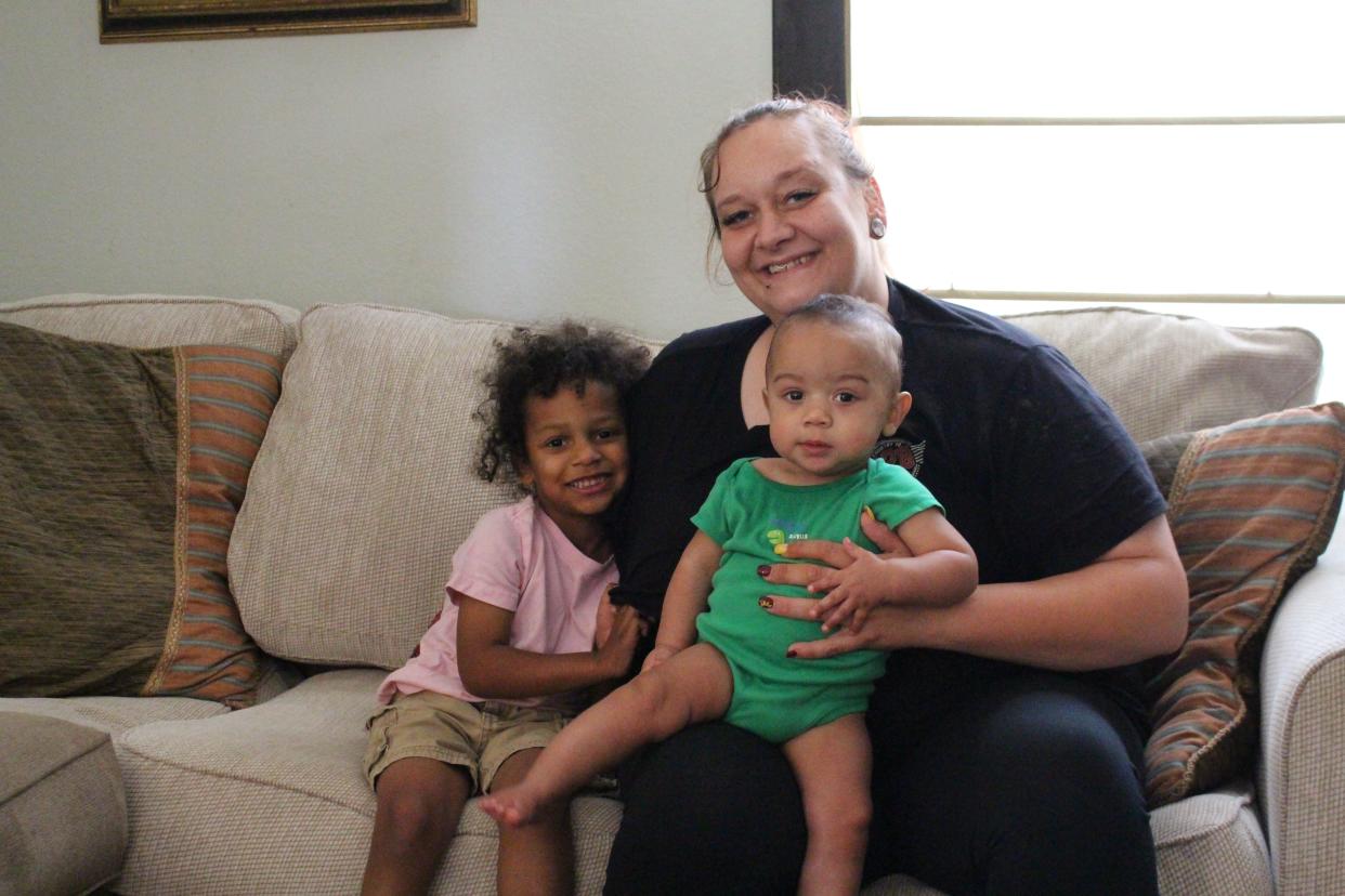 Kenzie Sims, 3, sits next to his mom, Michelle Allison, 32, and his 8-month-old brother Kingston, inside the Esther Home, a residence in Next Step Homeless Services’ transitional housing program in Fort Smith.